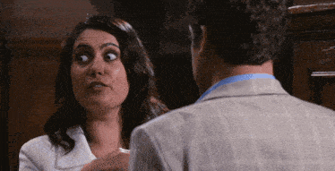 a man and a woman are looking at each other and the woman is making a face