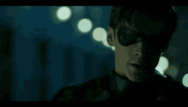 a close up of a man with the words fuck batman behind him
