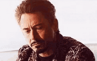 a close up of a man with a beard and mustache making a sad face .