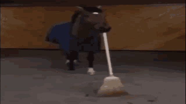 a horse with a broom sticking out its mouth