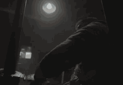 a man is wrapped in duct tape and sitting in a chair in a dark room .