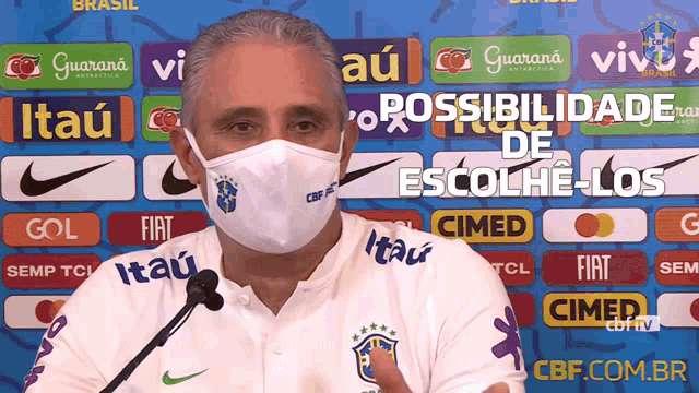 a man wearing a face mask is talking into a microphone in front of advertisements for itau guarana and fiat