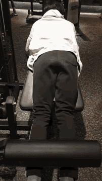 a person is laying on a bench in a gym with a sweatshirt that says ' abercrombie & fitch ' on it
