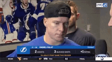a man wearing a hat stands in front of a fox broadcast