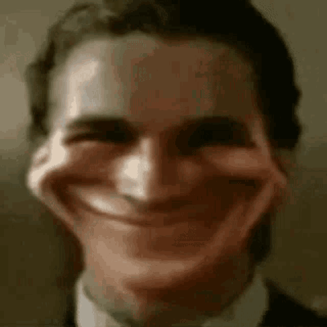 a man in a suit and tie is smiling with his mouth wide open .
