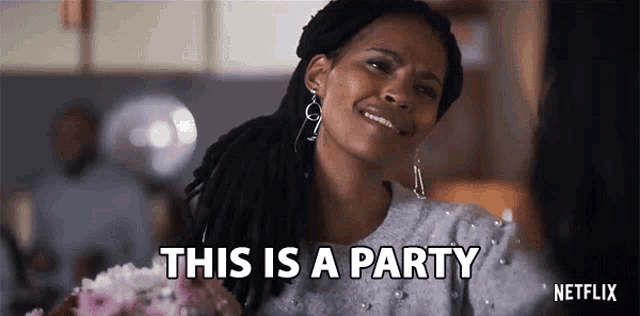 a woman with dreadlocks is holding a bouquet of flowers and says this is a party .