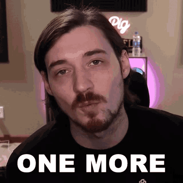 a man with a beard is wearing a black shirt with the words one more on it