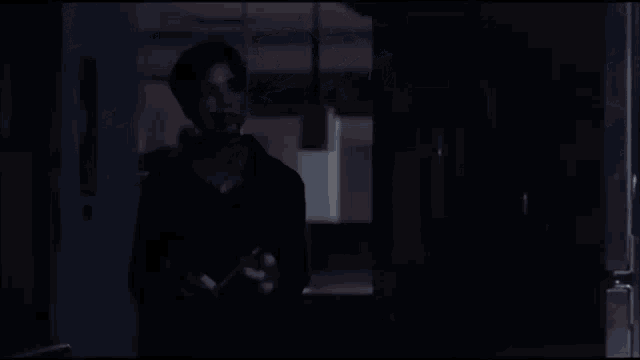 a woman in a black shirt is standing next to a table