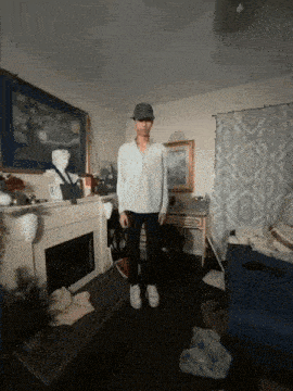 a man standing in a living room with a fireplace