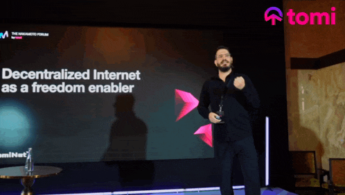 a man stands in front of a large screen that says " decentralized internet as a freedom enabler "