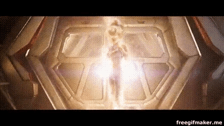 a person is standing in a dark room with a light coming out of the door .