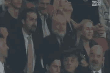 a group of people sitting in a stadium with a sign that says rai 2 on it .