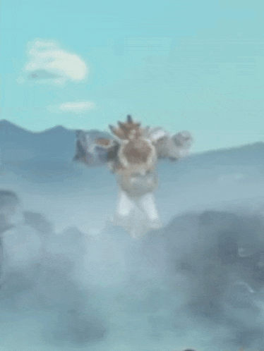 a blurred image of a person standing on top of a rock in the fog .