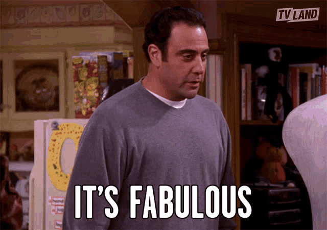 a man says it 's fabulous while standing in front of a refrigerator
