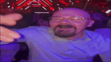 a man with glasses and a beard is sitting in a chair with his arms outstretched .