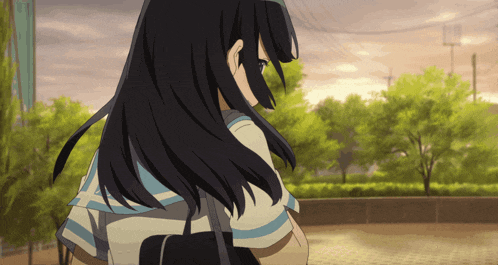 a girl with long black hair is standing in a park with trees in the background