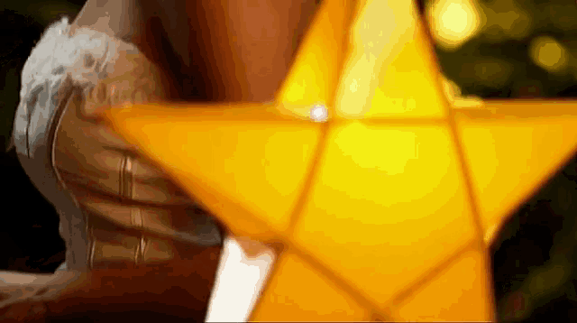 a woman in a white dress holds a yellow star