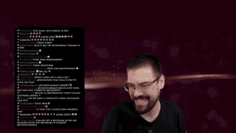 a man wearing glasses stands in front of a screen with a bunch of messages on it