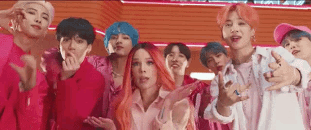 a group of people are standing next to each other in a room and making funny faces .