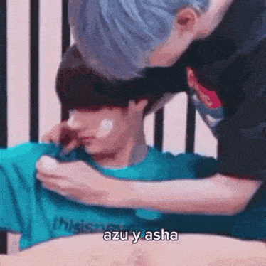 a couple of people standing next to each other and one of them is applying lotion to the other 's face .