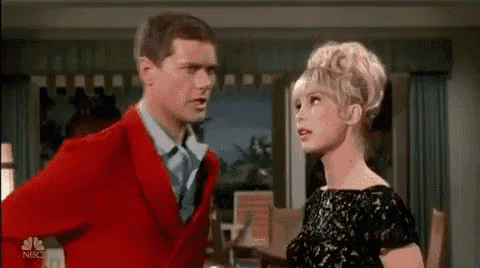 a man and a woman are standing next to each other in a living room .