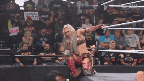 a woman in a wrestling ring holds a sign that says " generation x "