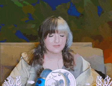 a woman is sitting on a couch with a picture of a fish on her shoulder
