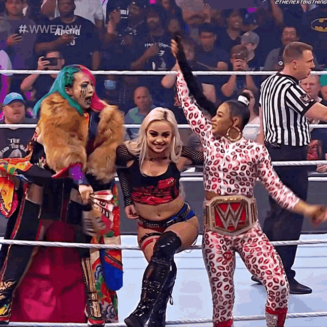 two women in a wrestling ring with a referee behind them and a #wwe hashtag