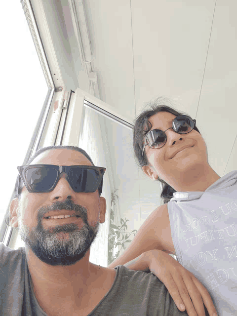 a man wearing sunglasses and a girl wearing a tank top that says " i love you "