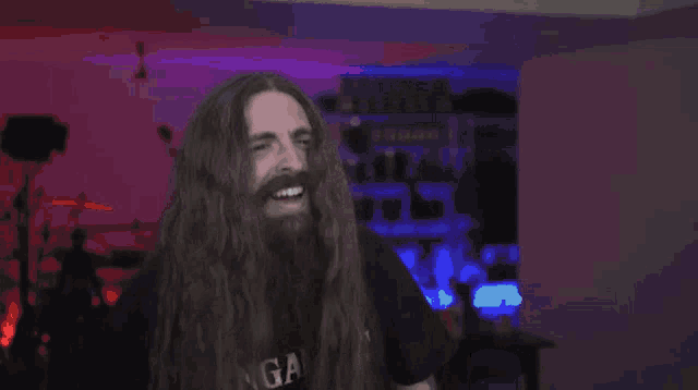 a man with long hair and a beard is wearing a shirt that says gapi