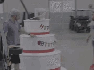 a man is standing next to a birthday cake with a panda mascot on top of it .