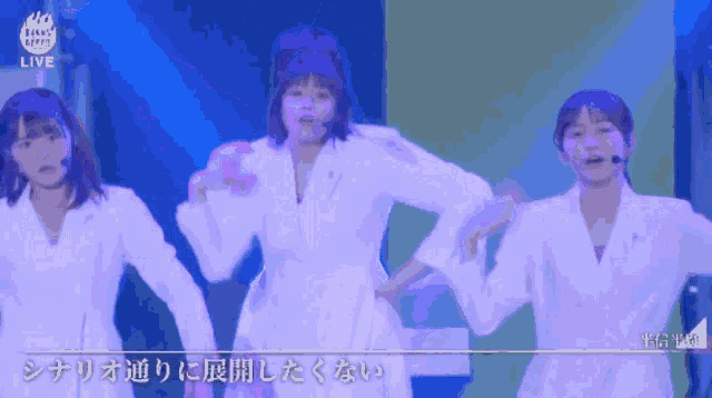 a group of women are dancing in front of a sign that says ' live ' on it