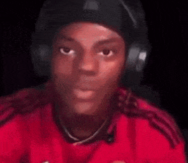 a blurry picture of a man wearing headphones and a red jersey .