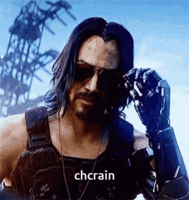 a man wearing sunglasses and a robotic arm is standing in front of a building and says chrain .