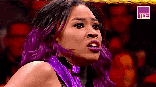 a woman with purple hair is standing in front of a crowd