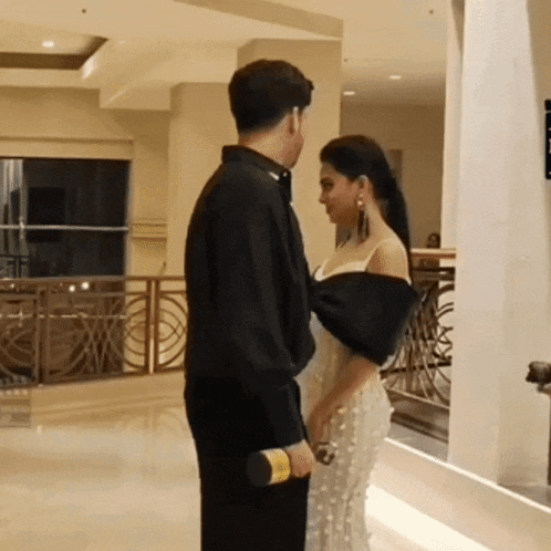 a man and a woman are looking at each other in a hallway
