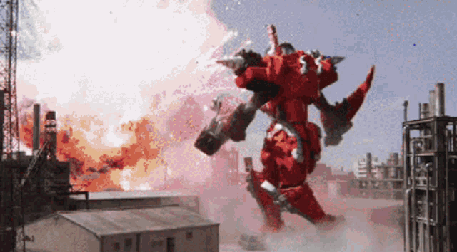 a red robot is flying through the air in front of buildings