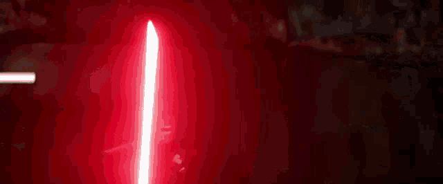 a red light is shining on a white background in the dark .