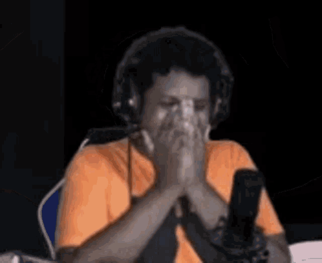 a man wearing headphones is sitting in front of a microphone and dancing .