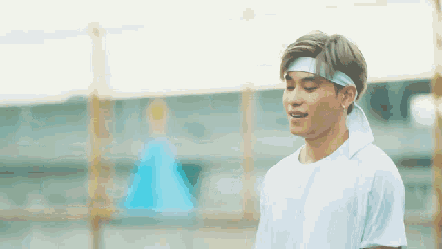 a young man wearing a headband is smiling