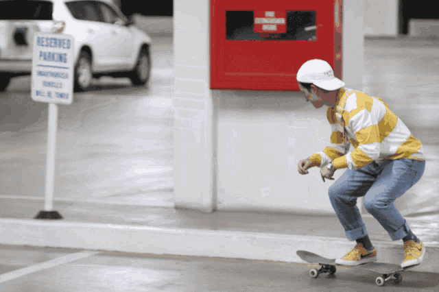 a man is riding a skateboard in front of a sign that says reserved parking