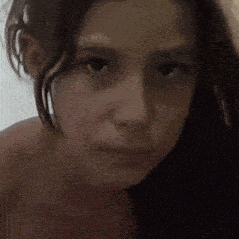 a close up of a young girl 's face with a serious look on her face