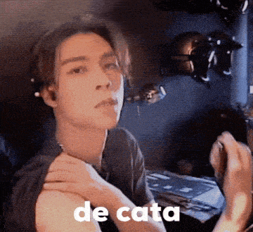 a young man is smoking a cigarette and has the word de cata written on his arm