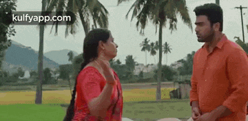 a man and woman are standing next to each other in a field .