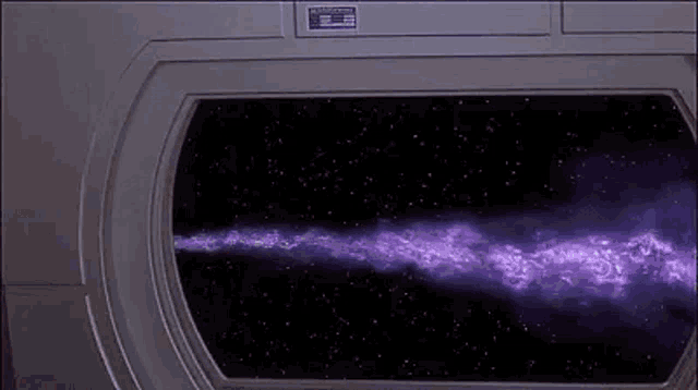 a purple beam is coming out of a window in a space ship .