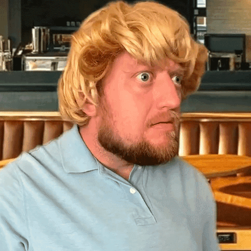 a man with a beard wearing a blonde wig and a blue shirt