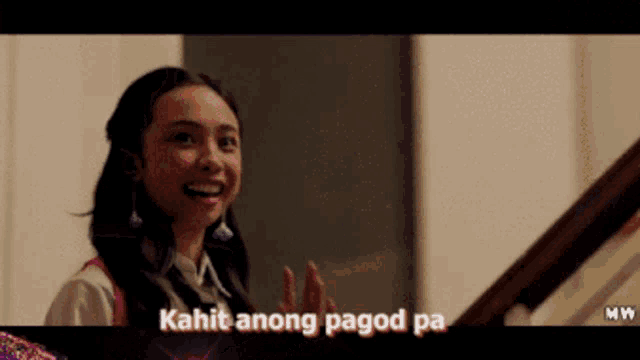 a girl is smiling with the words kahit anong pagod pa above her