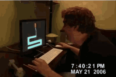 a man is typing on a keyboard in front of a computer screen with a snake on it ..