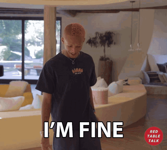 a man standing in a living room with the words i 'm fine on the bottom