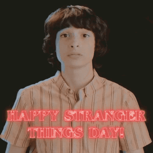 a boy in a striped shirt says happy stranger things day in red letters
